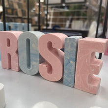 Load image into Gallery viewer, Jesmonite letters spelling the name Rosie, in pink and white and blue and white. 
