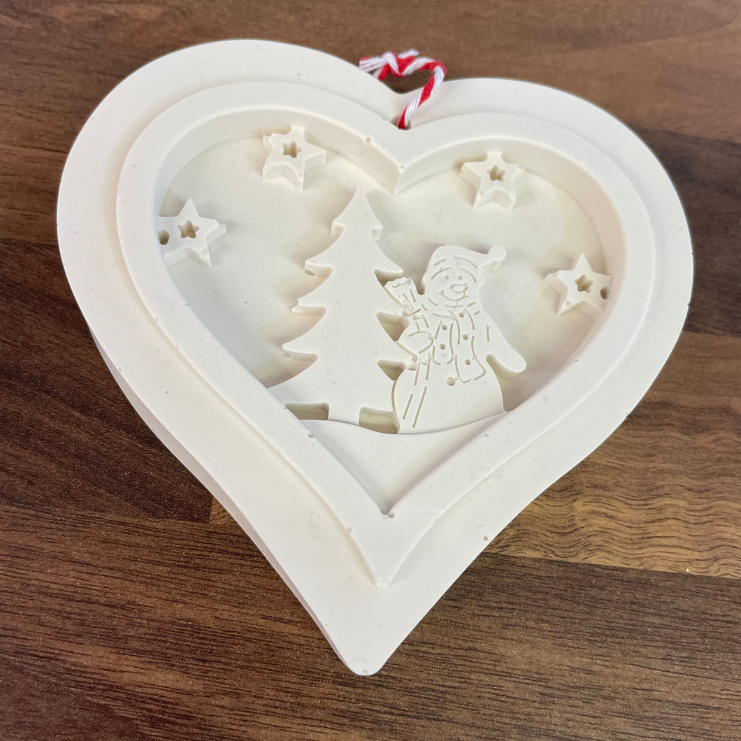 White Heart shaped Jesmonite christmas tree decoration showing a snowman stood next to a fir tree surrounded by stars.